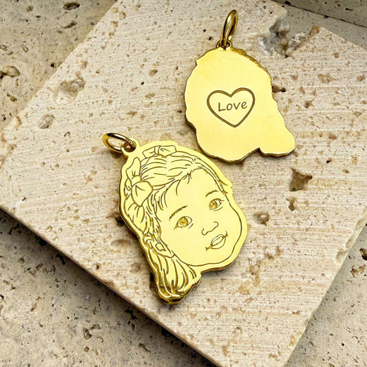18k Gold Vermeil custom 3D engraved baby portrait pendant on a textured stone surface