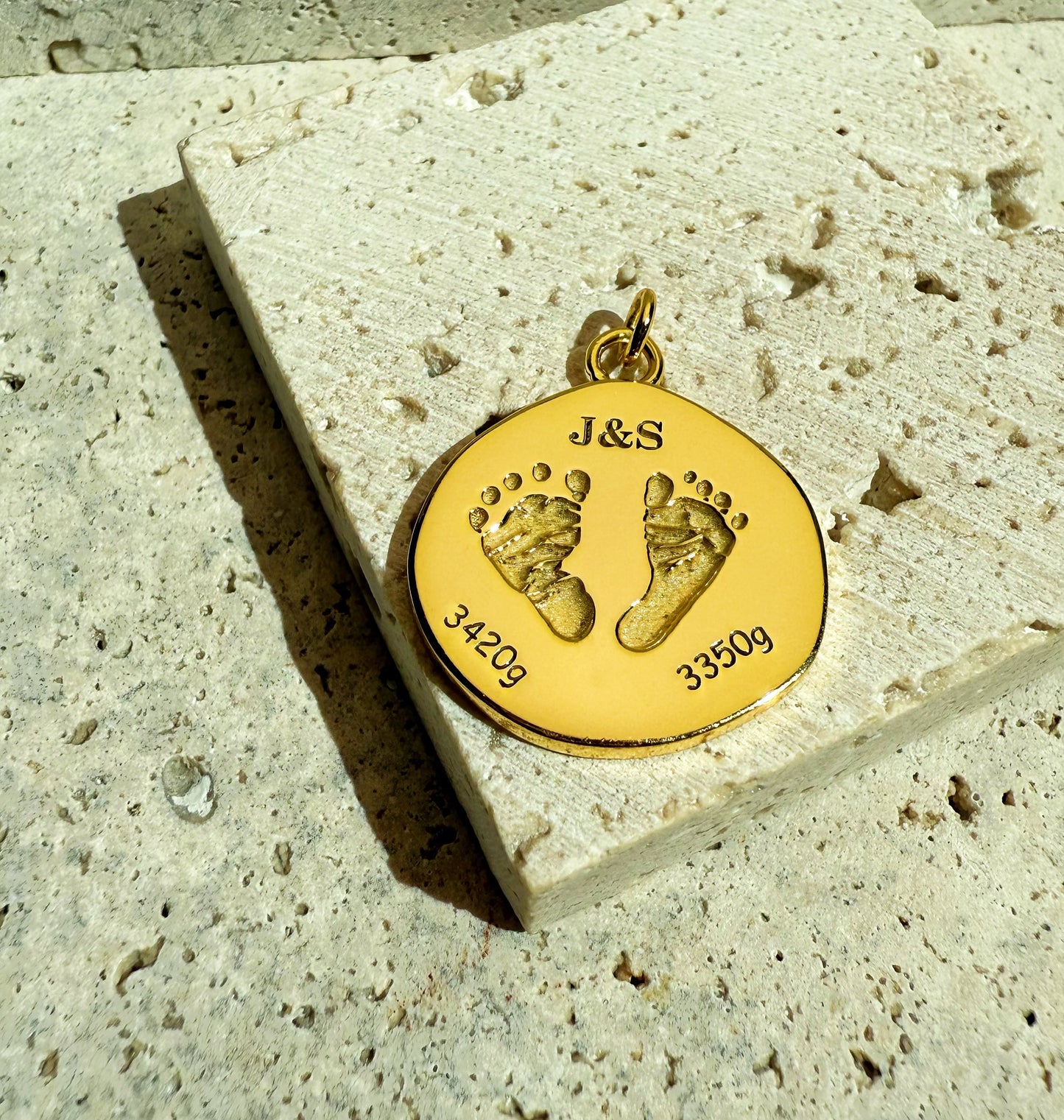 18k Gold Vermeil personalize baby foot print pendant on a textured background
