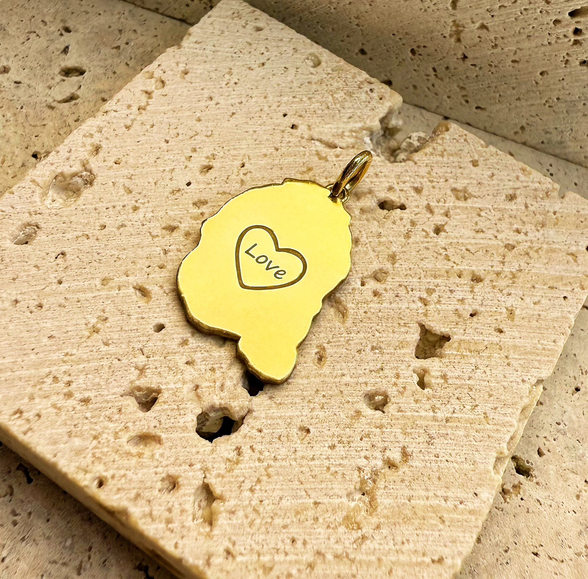 back of custom 3D engraved baby portrait pendant with letter engraved|18k Gold Vermeil on a textured stone surface